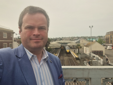 Kevin Foster MP with Paignton Station in the background.